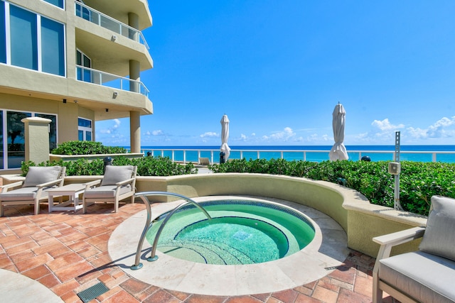 view of swimming pool with a water view, a hot tub, and a patio area