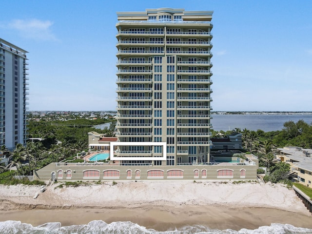 view of property with a beach view and a water view