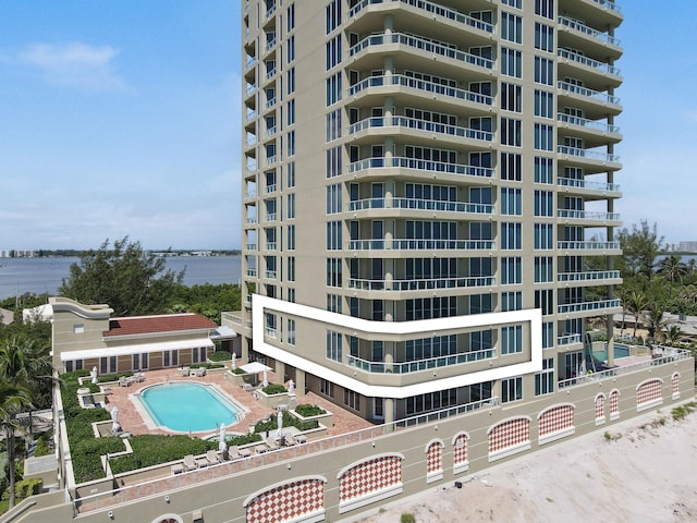 view of building exterior with a water view and a community pool