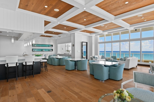 living room featuring a water view, coffered ceiling, wood ceiling, beam ceiling, and light hardwood / wood-style flooring