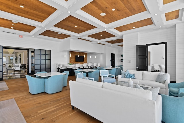 living room with light wood-type flooring, a high ceiling, coffered ceiling, and beamed ceiling