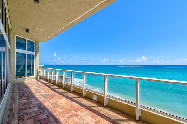 balcony featuring a water view and a beach view