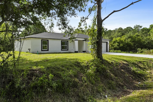 3848 NW 19th Ave, Okeechobee, FL 34972 - view of front facade with driveway, an attached garage, stucco siding, a front yard, and a shingled roof