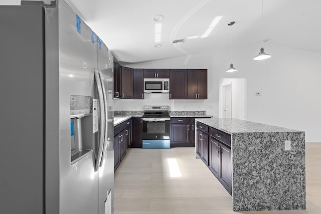 3848 NW 19th Ave, Okeechobee, FL 34972 - kitchen with appliances with stainless steel finishes, vaulted ceiling, dark brown cabinetry, a center island, and light stone countertops