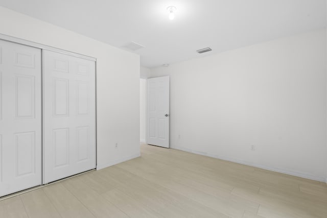 3848 NW 19th Ave, Okeechobee, FL 34972 - unfurnished bedroom with light wood finished floors, a closet, and baseboards