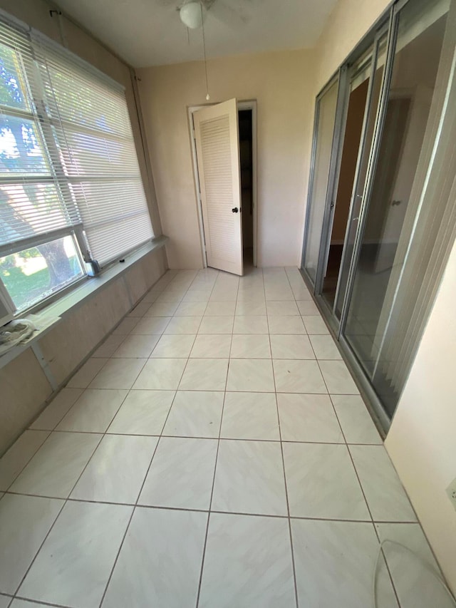 unfurnished sunroom featuring ceiling fan