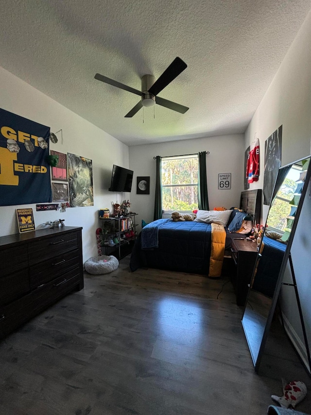 bedroom with ceiling fan, a textured ceiling, and dark hardwood / wood-style flooring