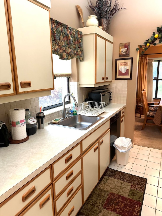 kitchen with black dishwasher, sink, and backsplash