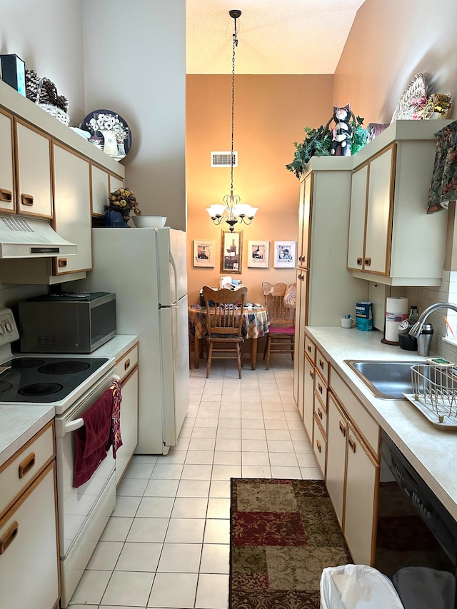 kitchen featuring hanging light fixtures, light tile patterned floors, a notable chandelier, sink, and white appliances