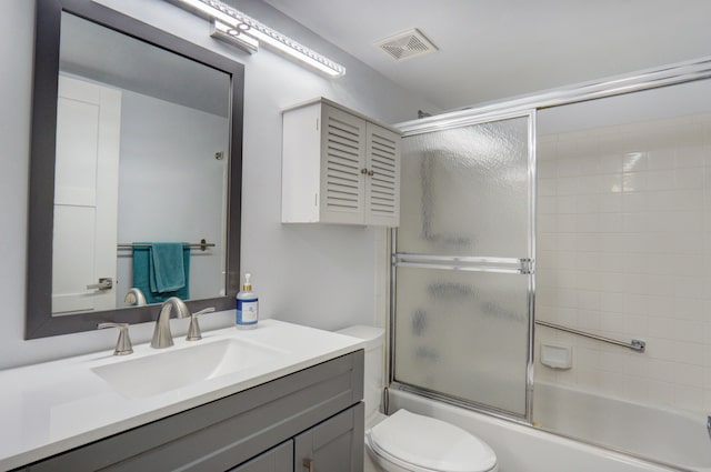 full bathroom featuring shower / bath combination with glass door, vanity, and toilet