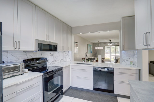 kitchen with tasteful backsplash, sink, black appliances, white cabinets, and hanging light fixtures