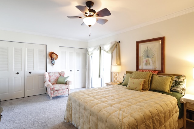 bedroom featuring ceiling fan, carpet flooring, ornamental molding, and two closets