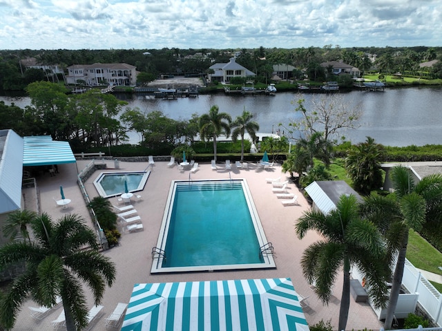 view of swimming pool with a water view and a patio area