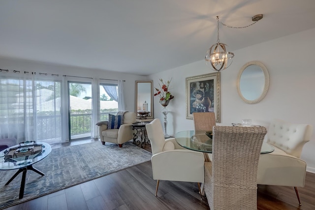 dining area featuring dark wood-type flooring and a chandelier