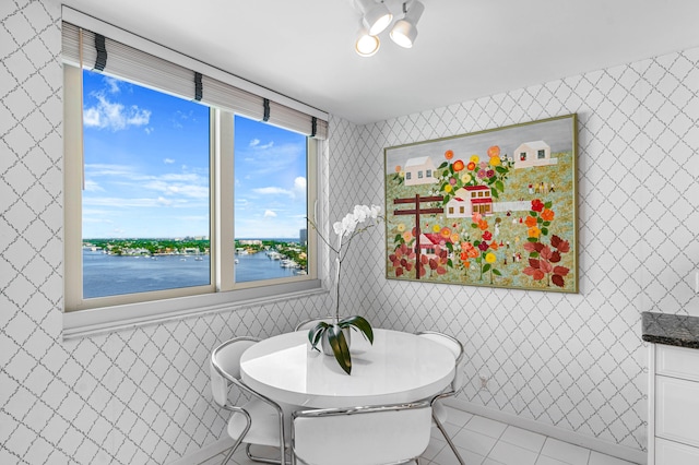 tiled dining room with tile walls and a water view