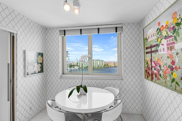 dining space featuring a water view and light tile patterned flooring