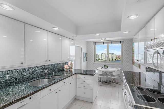 kitchen featuring sink, white appliances, and white cabinetry