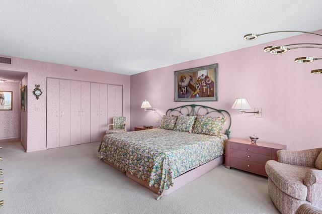 bedroom with light colored carpet and a textured ceiling