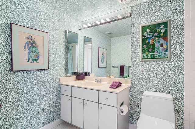 bathroom featuring a textured ceiling, vanity, and toilet