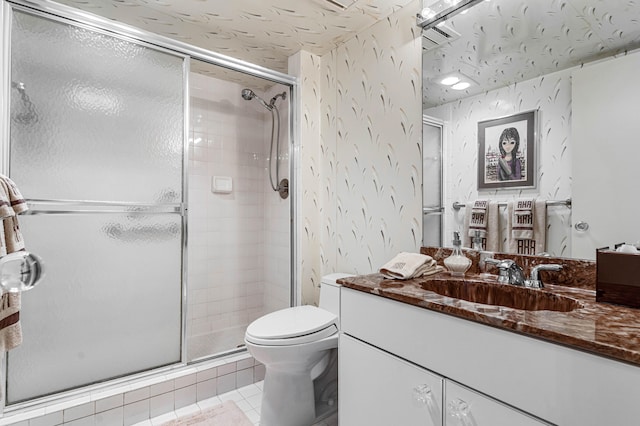 bathroom with walk in shower, vanity, tile patterned flooring, and toilet