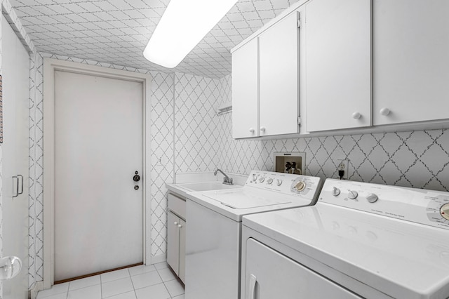 washroom featuring washing machine and clothes dryer, cabinets, light tile patterned floors, and sink