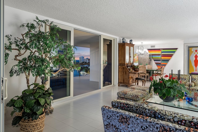 living room featuring a notable chandelier, a textured ceiling, and tile patterned floors