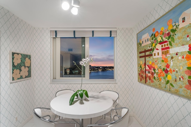 tiled dining area featuring tile walls and a water view