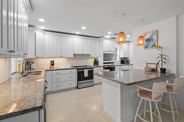 8045 W Lake Dr, Lake Clarke Shores, FL 33406 - kitchen with stainless steel electric stove, a sink, a peninsula, dark stone counters, and white cabinets