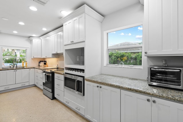 8045 W Lake Dr, Lake Clarke Shores, FL 33406 - kitchen featuring range with electric cooktop, stainless steel microwave, a sink, recessed lighting, and white cabinets