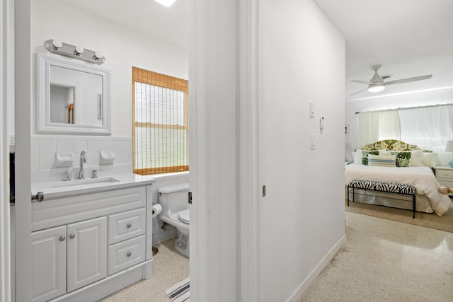 8045 W Lake Dr, Lake Clarke Shores, FL 33406 - bathroom with toilet, vanity, a ceiling fan, connected bathroom, and decorative backsplash