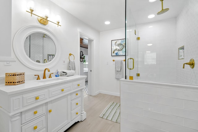 8045 W Lake Dr, Lake Clarke Shores, FL 33406 - bathroom featuring tiled shower, wood finished floors, vanity, baseboards, and recessed lighting
