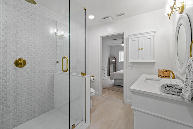 8045 W Lake Dr, Lake Clarke Shores, FL 33406 - bathroom with wood finished floors, a tile shower, ensuite bath, vanity, and toilet