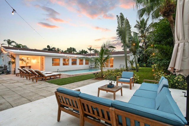 8045 W Lake Dr, Lake Clarke Shores, FL 33406 - patio terrace at dusk with an outdoor living space and an outdoor pool