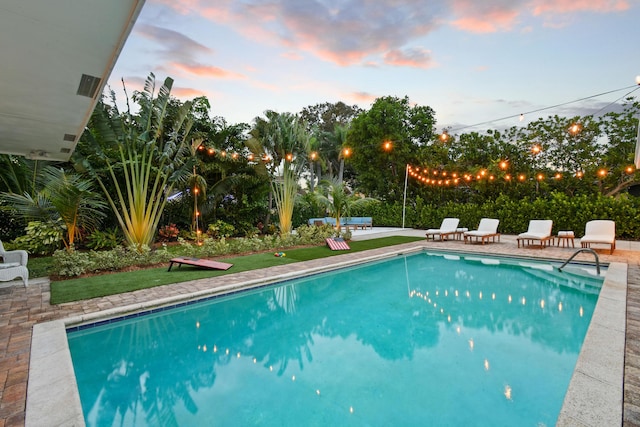 8045 W Lake Dr, Lake Clarke Shores, FL 33406 - pool at dusk featuring an outdoor pool and a patio area