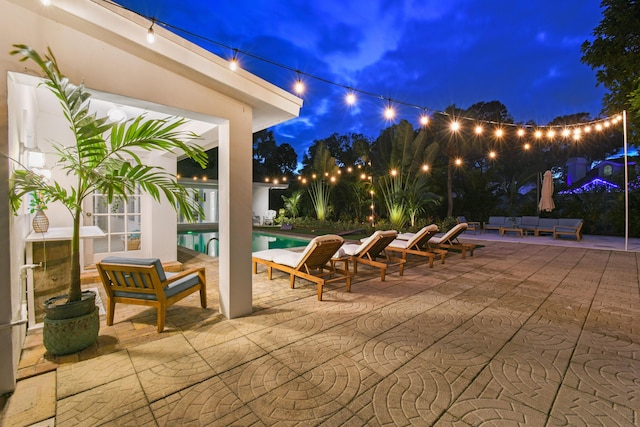 8045 W Lake Dr, Lake Clarke Shores, FL 33406 - patio at night with an outdoor living space and an outdoor pool