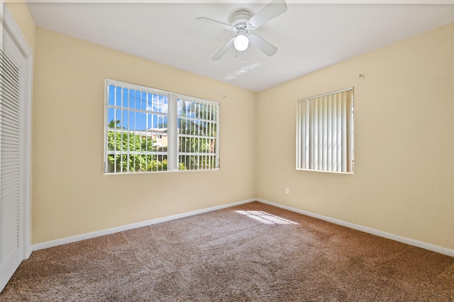 carpeted spare room with ceiling fan