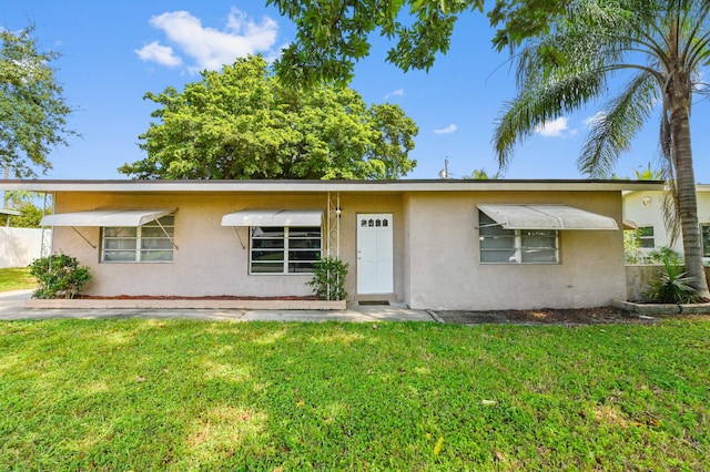 single story home featuring a front lawn