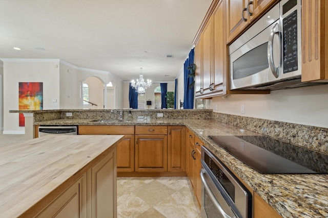 kitchen with sink, an inviting chandelier, stainless steel appliances, crown molding, and butcher block countertops