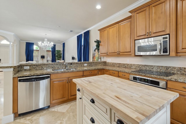 kitchen featuring an inviting chandelier, a center island, appliances with stainless steel finishes, and wood counters