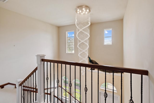 stairs featuring a chandelier