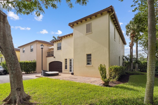 rear view of house with a yard and a garage