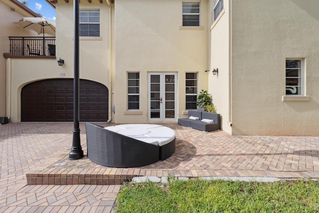 view of patio featuring a balcony and a garage