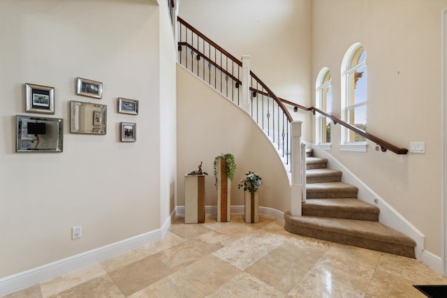 stairway featuring a towering ceiling