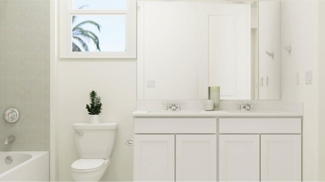 full bathroom with tiled shower / bath combo, vanity, and toilet