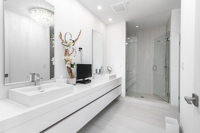 full bath with a stall shower, visible vents, a sink, and double vanity