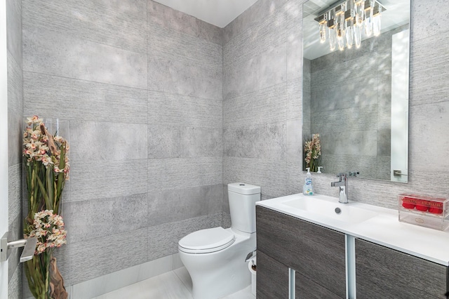 bathroom featuring toilet, backsplash, tile walls, and vanity