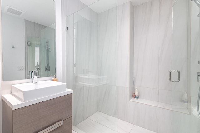 full bath featuring a stall shower, vanity, and visible vents