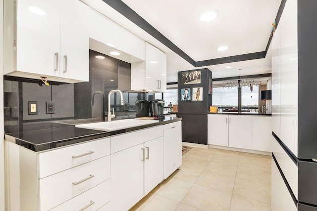 kitchen featuring white cabinetry, light tile patterned flooring, tasteful backsplash, and sink