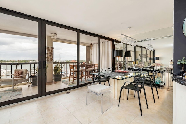 dining space with a notable chandelier, a wall of windows, and light tile patterned floors