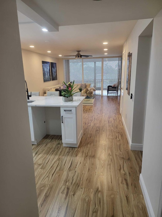 kitchen with white cabinetry, kitchen peninsula, and light wood-type flooring